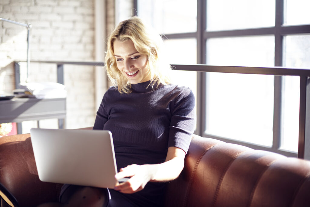 Young Woman Sitting On A Sunny Office Couch